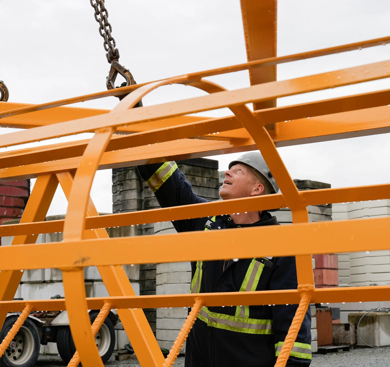 A worker attaches rigging to a load.
