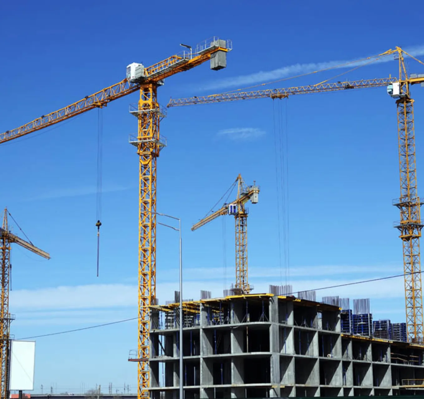 Four tower cranes are operating over a highrise development.