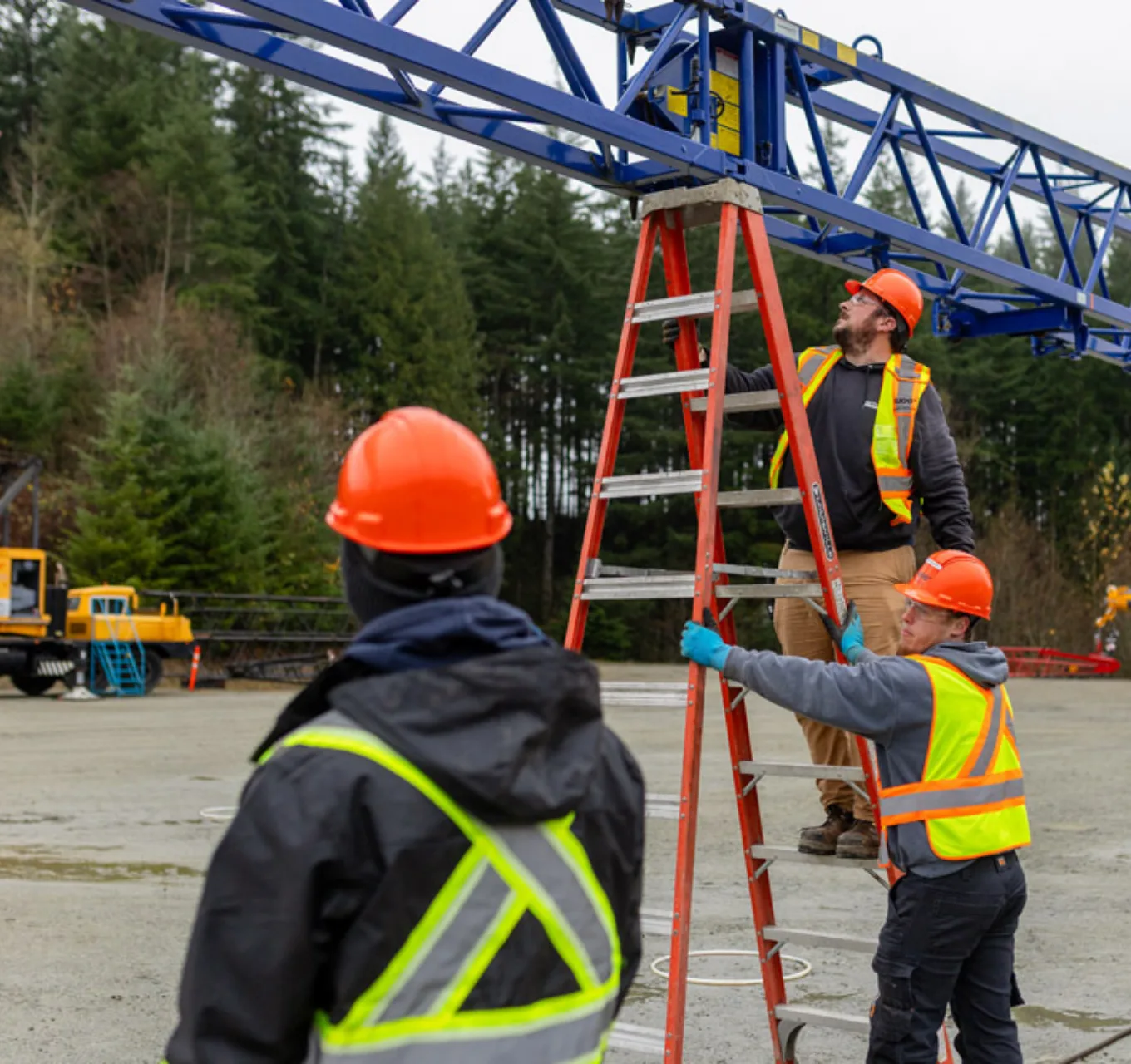 Provisional crane operators in training work on the boom of a crane.