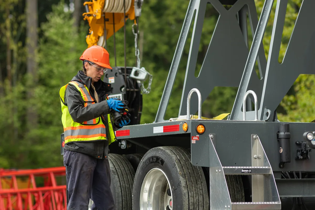 A female crane operator works on a mobile crane.