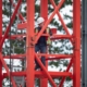 Man climbing up a red tower crane