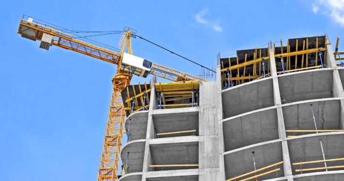 Crane and building construction site against blue sky