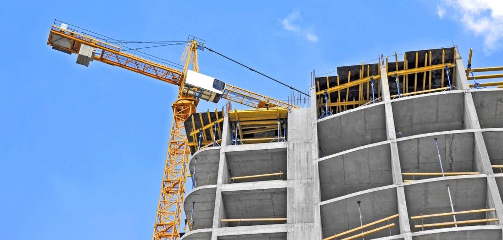 Crane and building construction site against blue sky